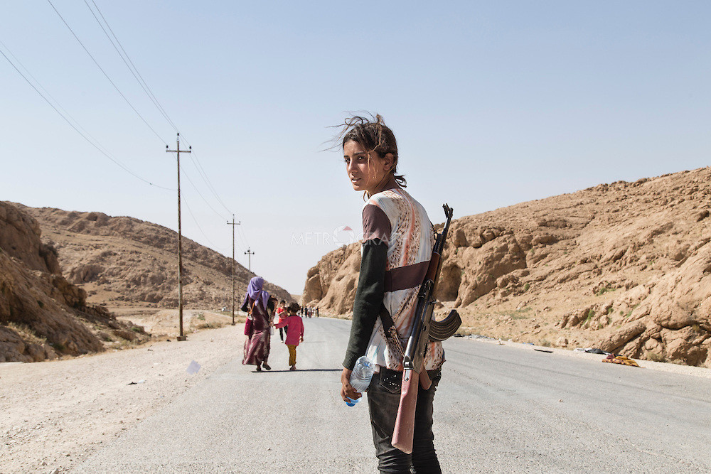 niña yezidi con fusil de asalto en el norte de iraq